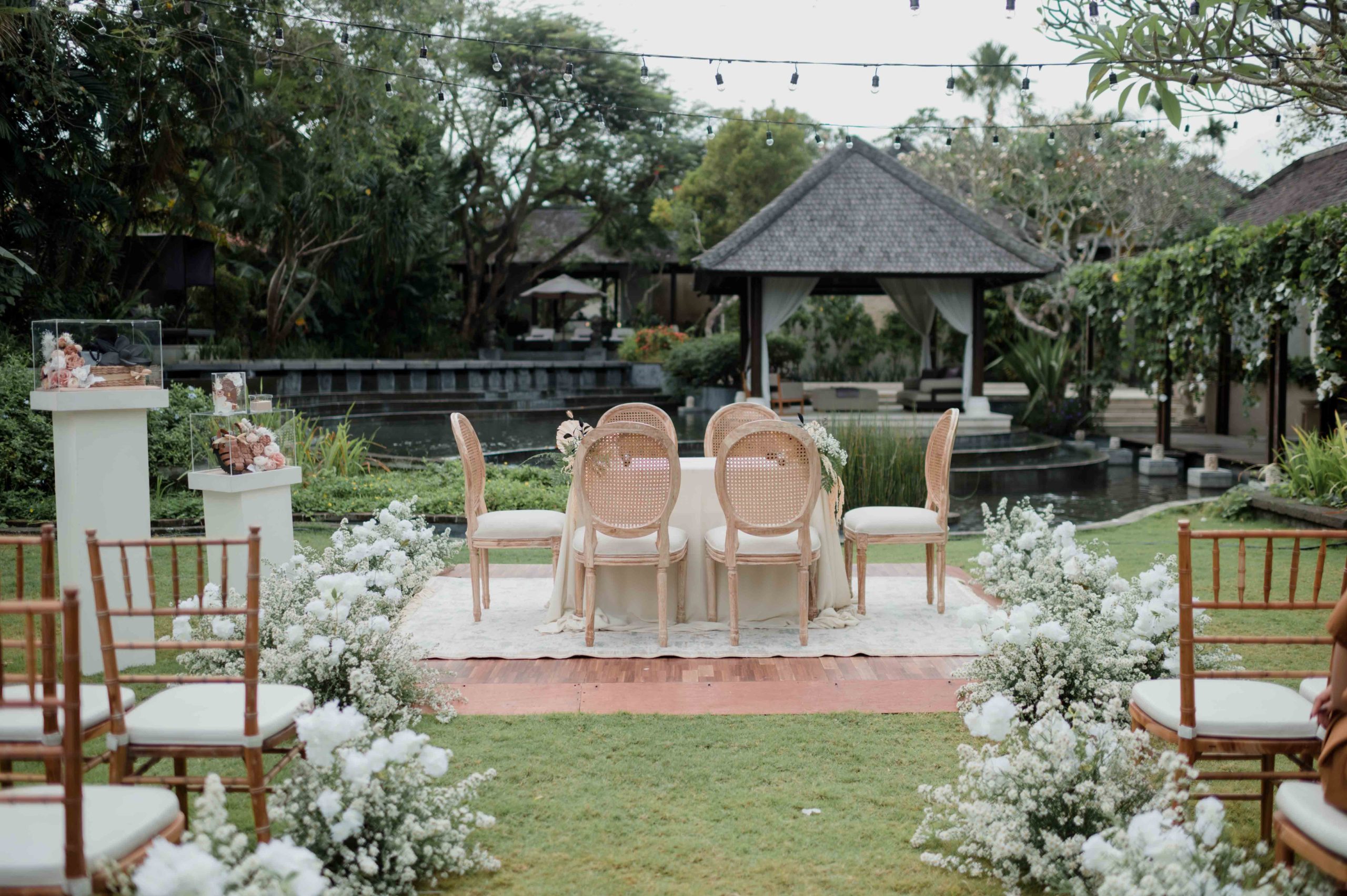 Garden ceremony aisle framed by tropical planting at Villa Air Bali, Seminyak