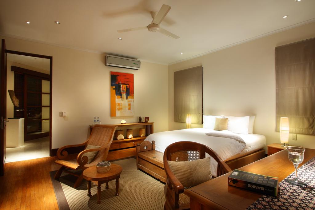 Guest bedroom at Villa Ali Agung with a king bed, warm lamplight, and a sitting area