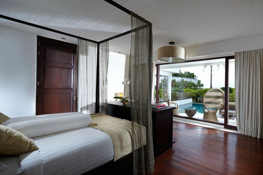 A Villa Anugrah bedroom suite with glass doors opening to a private pool deck