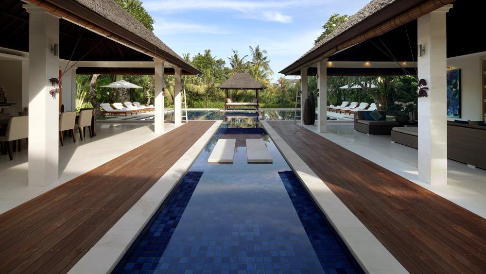 Villa Asante's reflection pool and twin pavilions in daylight, with the two-storey villa behind
