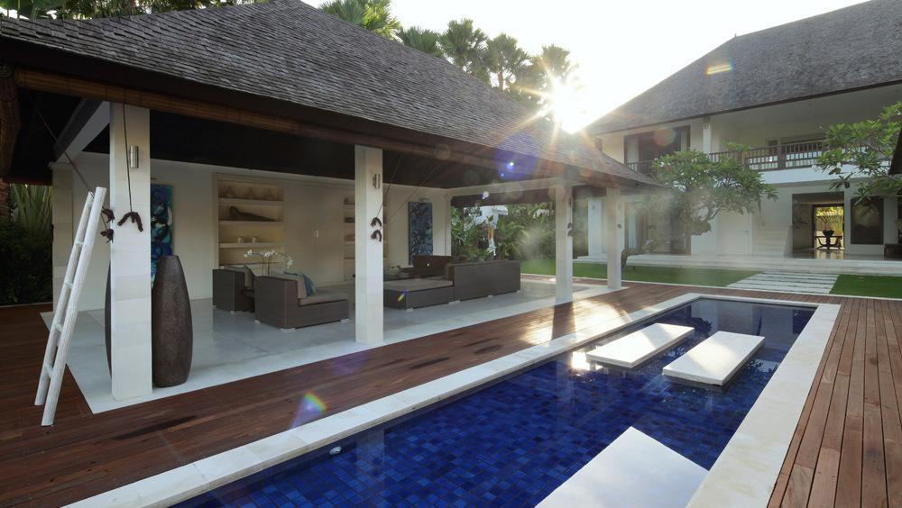 Open-air living pavilion at Villa Asante at sunrise, beside the pool