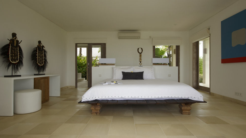 Master bedroom at Villa Babar with garden doors and Balinese art