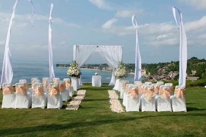 Wedding ceremony chairs and arbour set up on the clifftop lawn at Villa Bayuh Sabbha, ocean behind