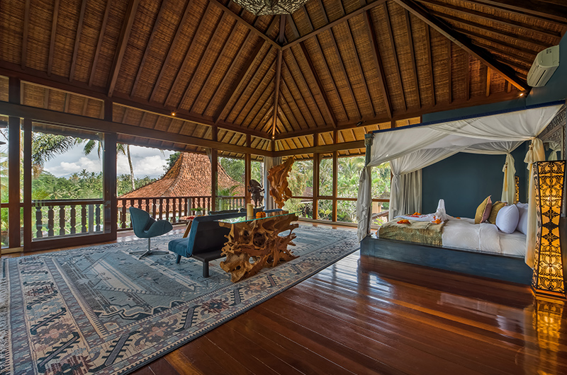 Open-sided bedroom pavilion at Villa Bodhi with a canopy bed under a high thatched roof and jungle views