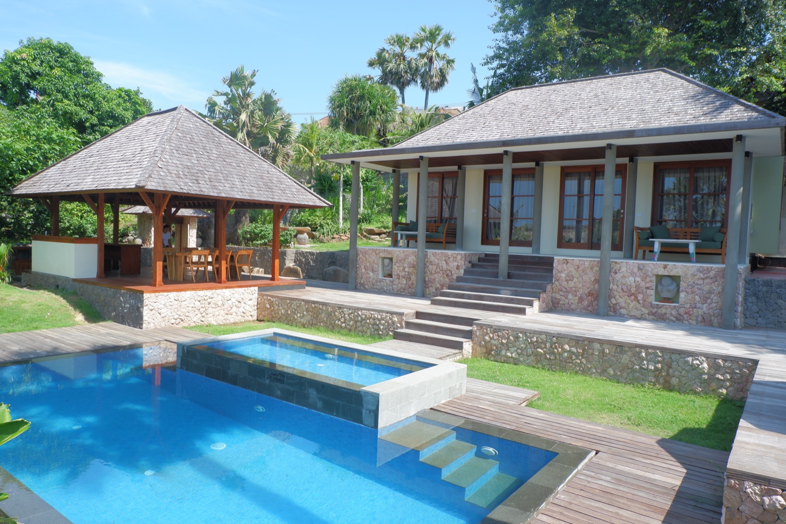 Guest house with a shingled bale and pool deck in the gardens at Villa Bukit Segara in Amed, east Bali