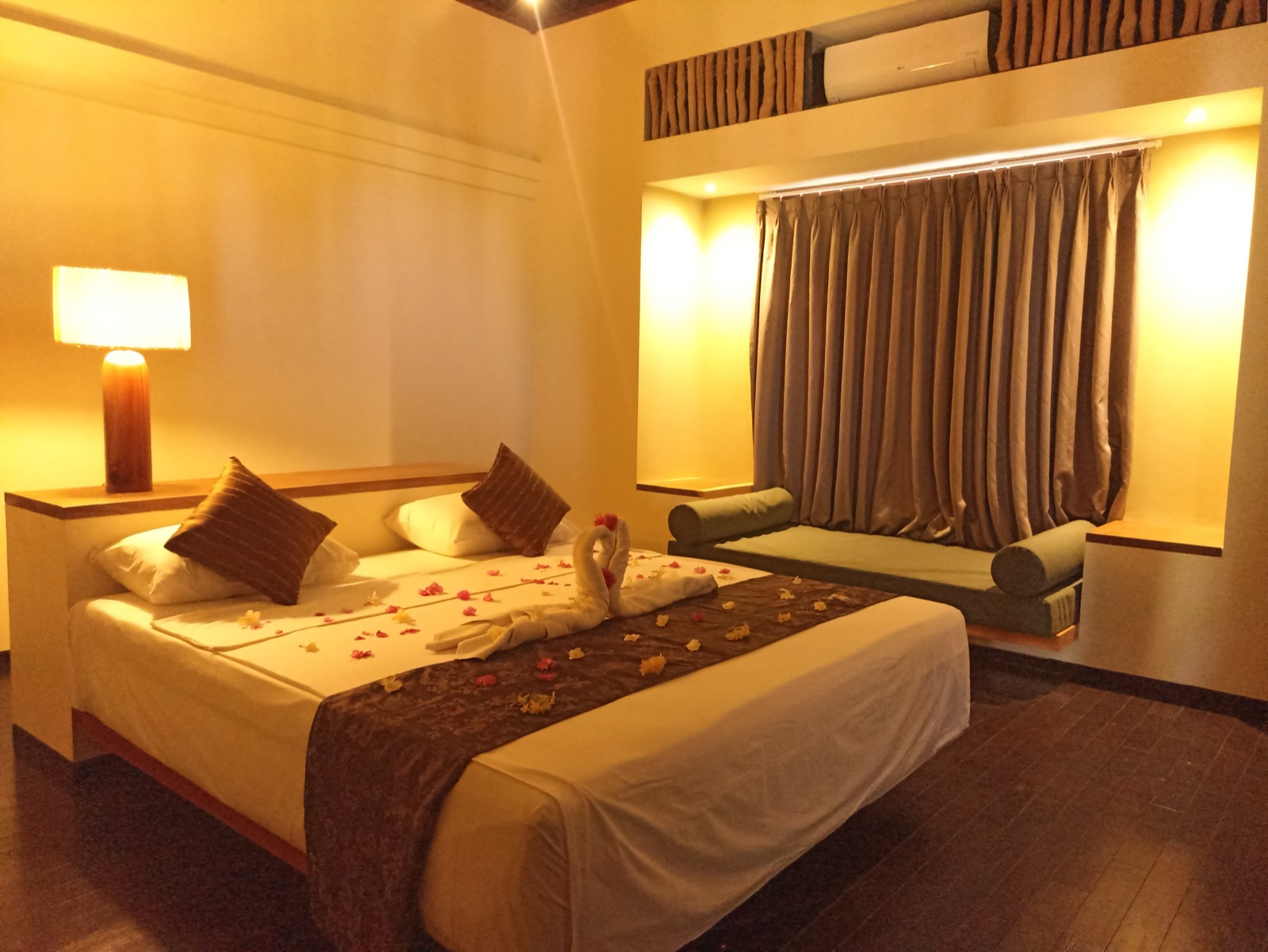 Bedroom with a towel swan and flower petals laid on the bed at Villa Bukit Segara in Amed, east Bali