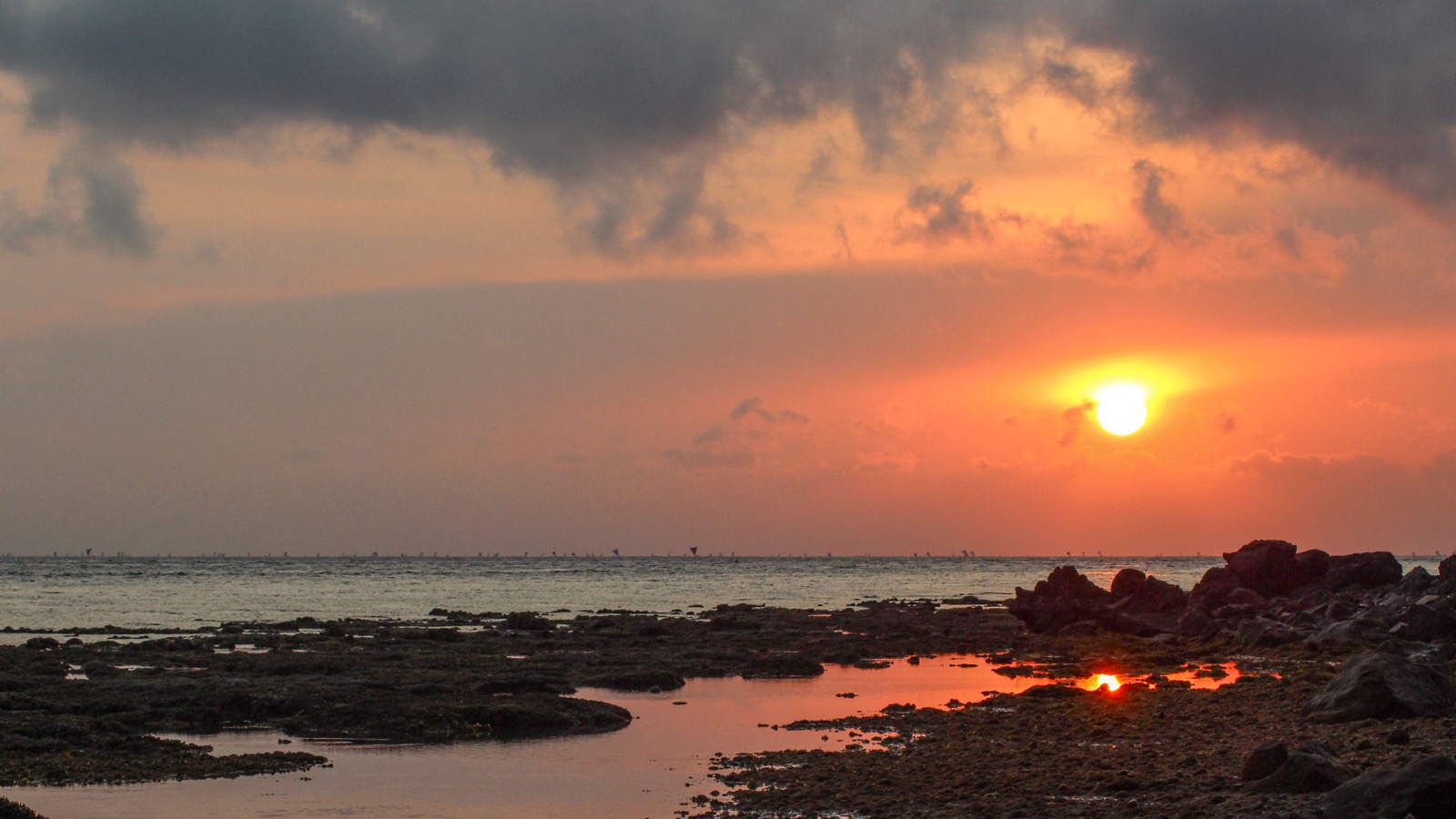 Sunrise over the reef flat and rocks on the shore below Villa Bukit Segara in Amed, east Bali