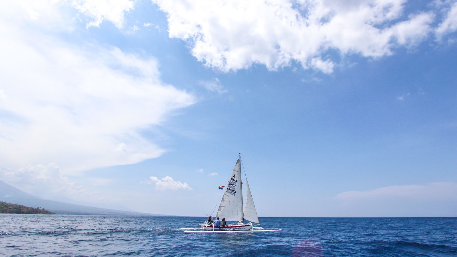 The estate sailing catamaran under full sail off the Amed coast in east Bali, run from Villa Bukit Segara