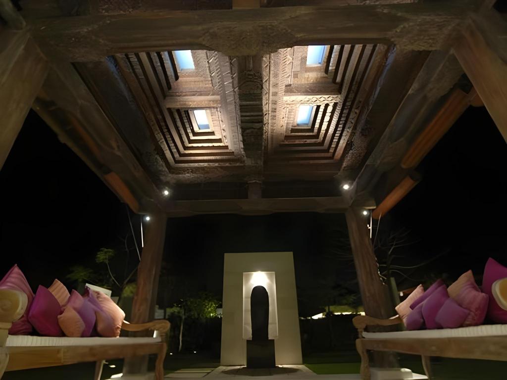 Traditional joglo ceiling and cushioned daybeds in Villa Cahaya's covered entrance pavilion