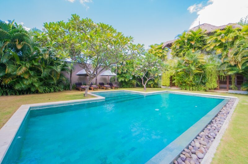 Villa Chocolat pool surrounded by tropical gardens and Balinese buildings, Oberoi Seminyak