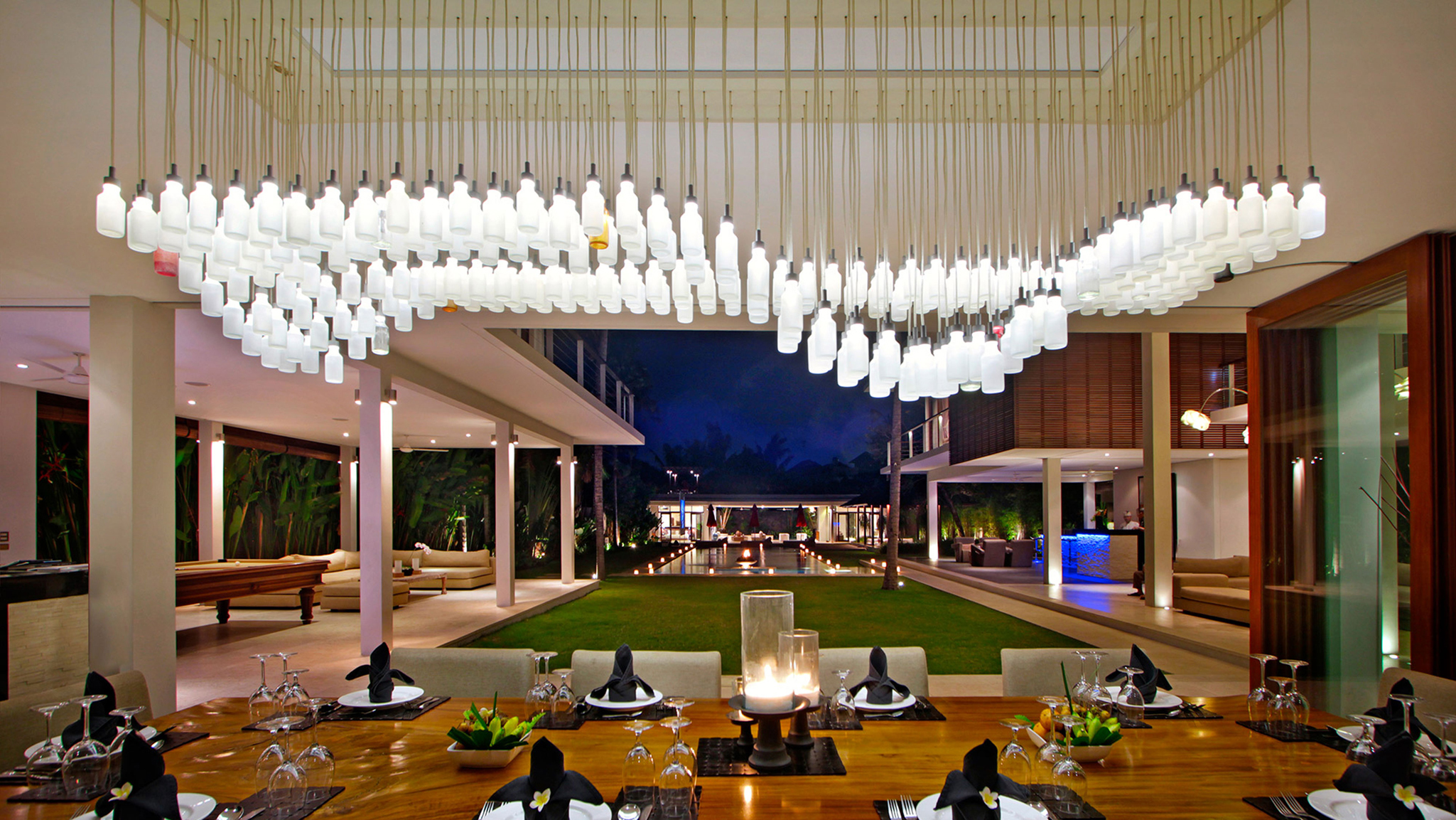 A dining table set for guests at night at Villa Kalyani