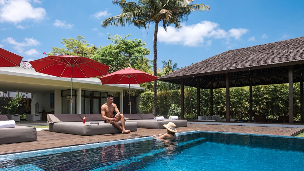 Relaxing pool area at Villa Kalyani surrounded by landscaped tropical gardens, Canggu