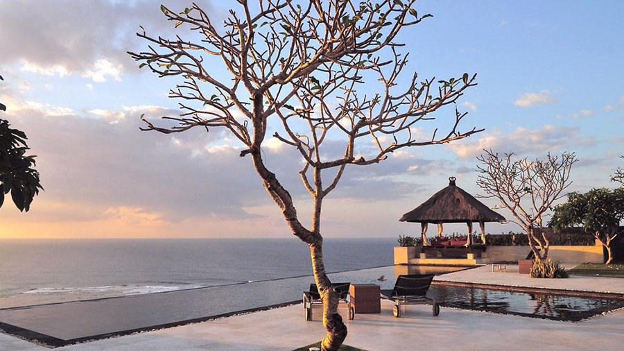 Thatched cliff-edge gazebo and day bed at Villa Karang Kembar Tiga at sunset