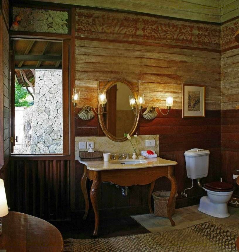 Neo-colonial en-suite bathroom at Villa Kirana with an oval mirror and carved timber walls