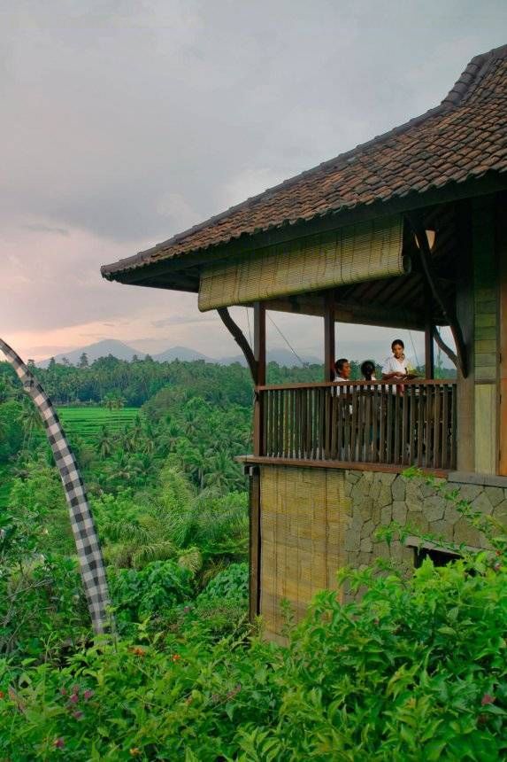 Guests on the master suite balcony at Villa Kirana, looking out over the valley and distant volcanoes