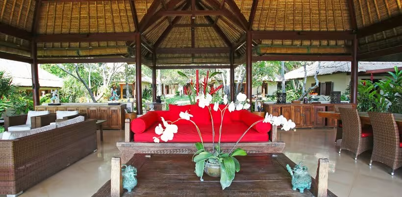 Open-sided living pavilion at Villa Maridadi with alang-alang roof looking out to the garden