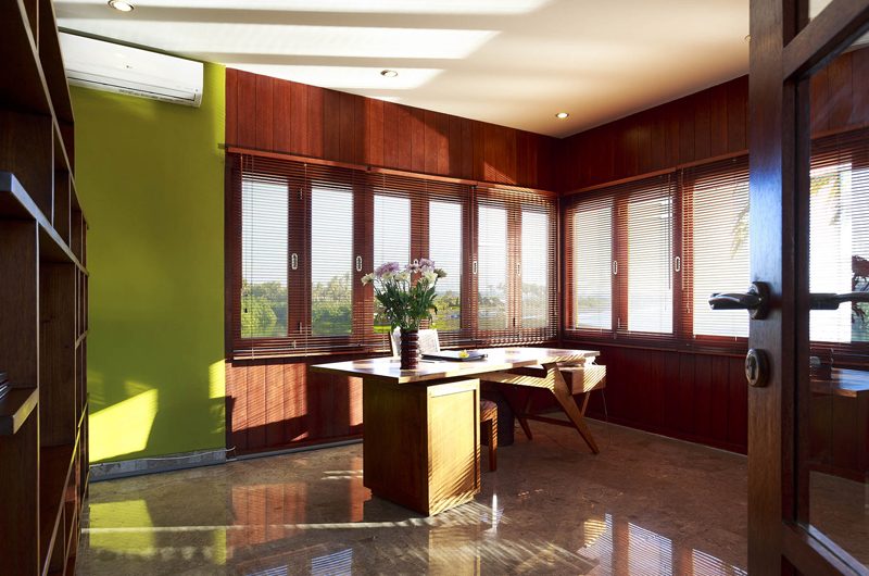 Study at Villa Pushpapuri with a timber desk and louvred windows opening to the rice fields