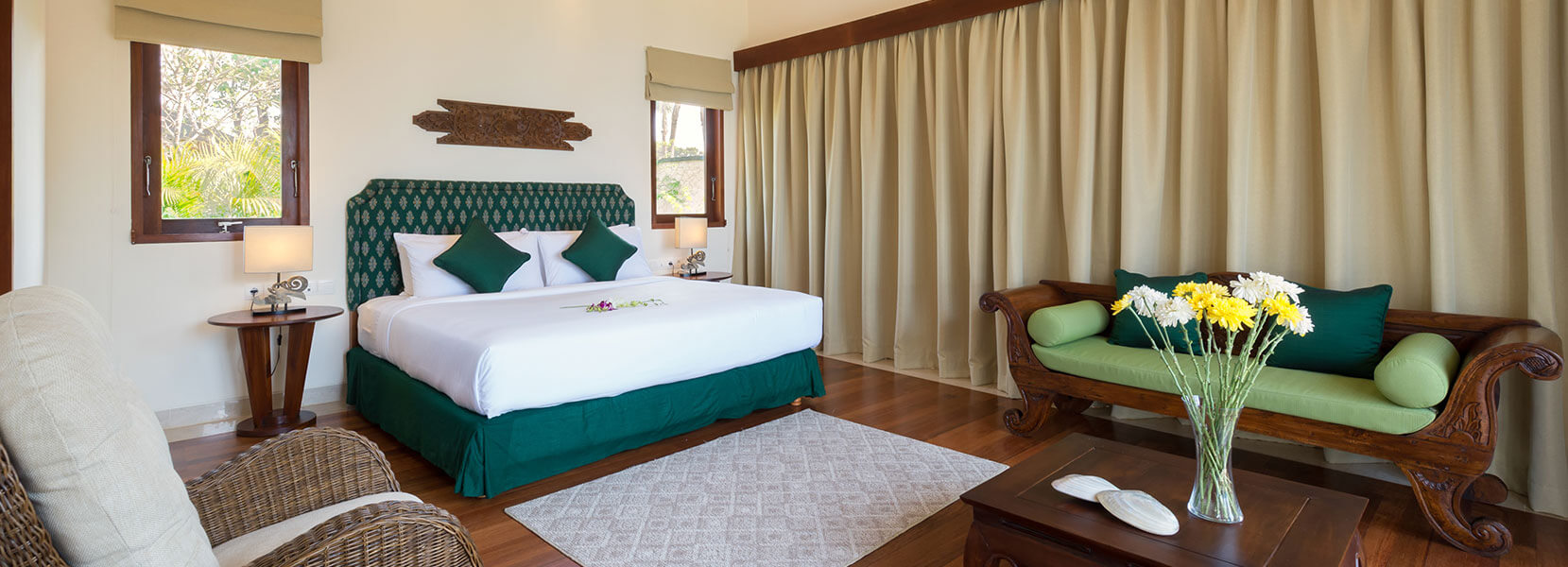 Bedroom at Villa Rose with a green upholstered headboard and antique daybed
