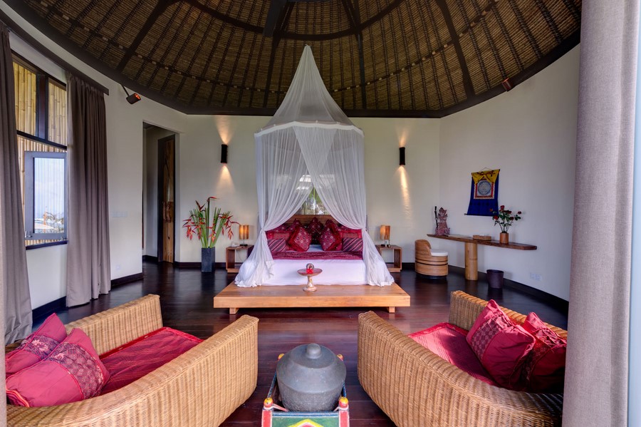 A round, thatched-roof bedroom pavilion at Villa Taman Ahimsa with a canopied bed