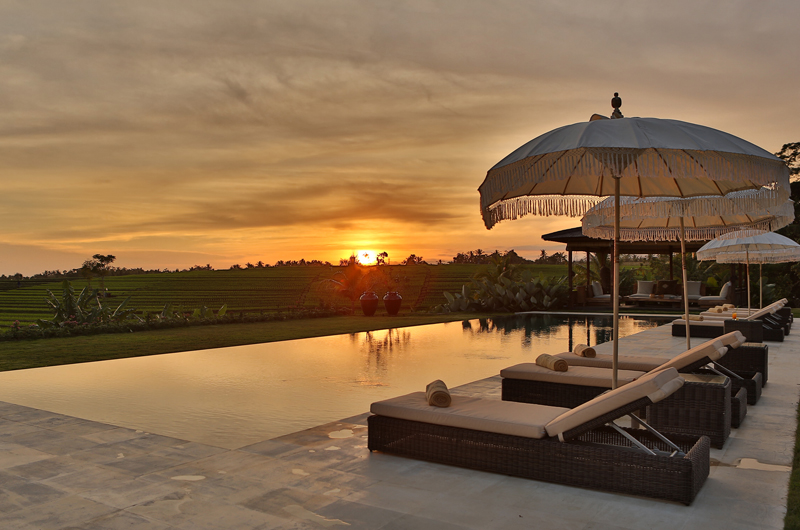 The 20-metre infinity pool at Villa Tangguntiti at sunset, looking out over the Tabanan rice fields