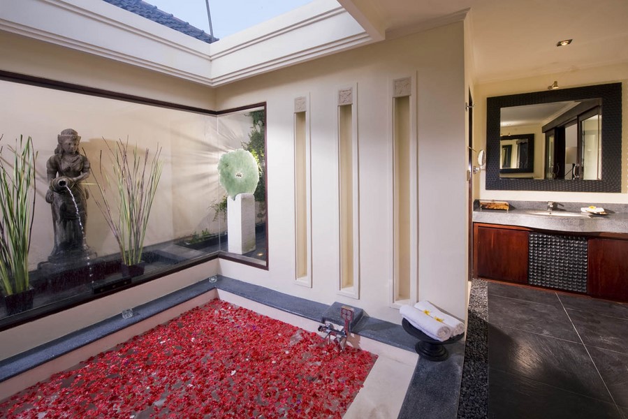 Outdoor bathtub scattered with flower petals at Villa Ylang Ylang