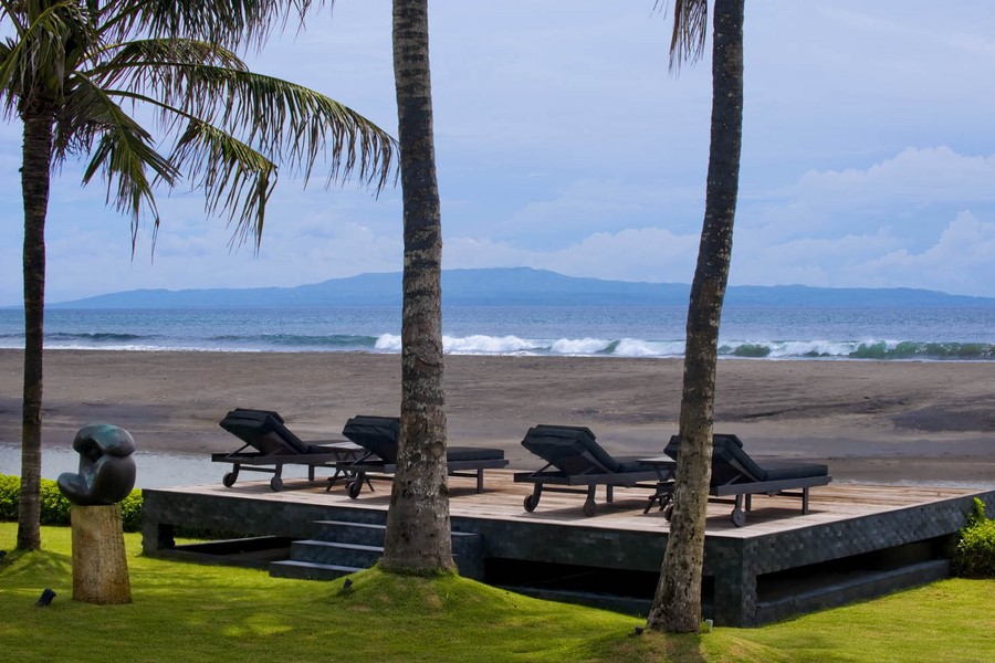Beachfront loungers under coconut palms facing the Indian Ocean at Villa Ylang Ylang, Ketewel